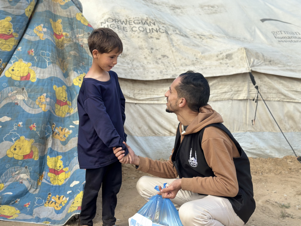 Islamic Relief staff with child; Give to a cause you care about the most this eofy