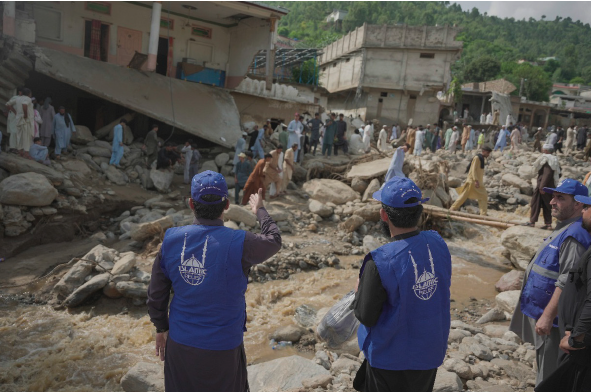 Families wading through floodwaters in northern Pakistan, after homes and livelihoods were washed away.