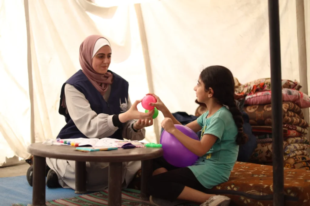 Islamic Relief aid worker and a sponsored orphan girl 