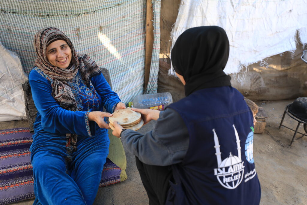 Islamic Relief staff in Gaza handing out aid to the needy (a mother) - one of the recipients of zakat