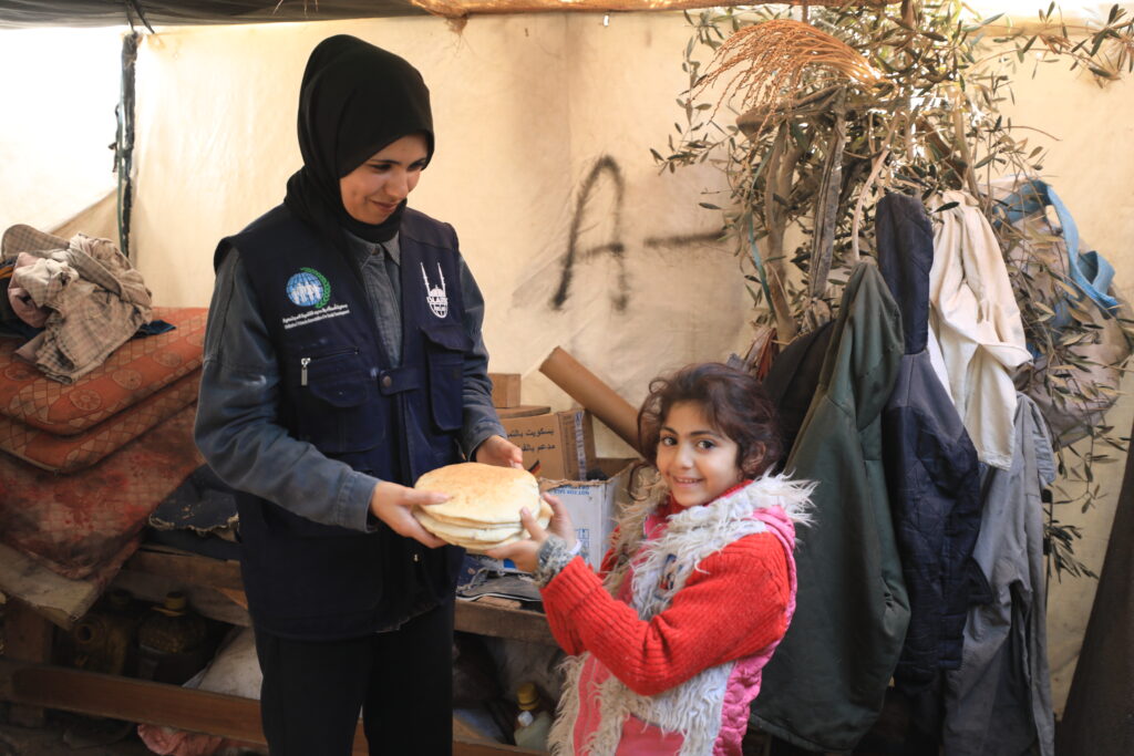 Islamic Relief staff in Gaza handing out aid to the needy (a girl child) - one of the recipients of zakat