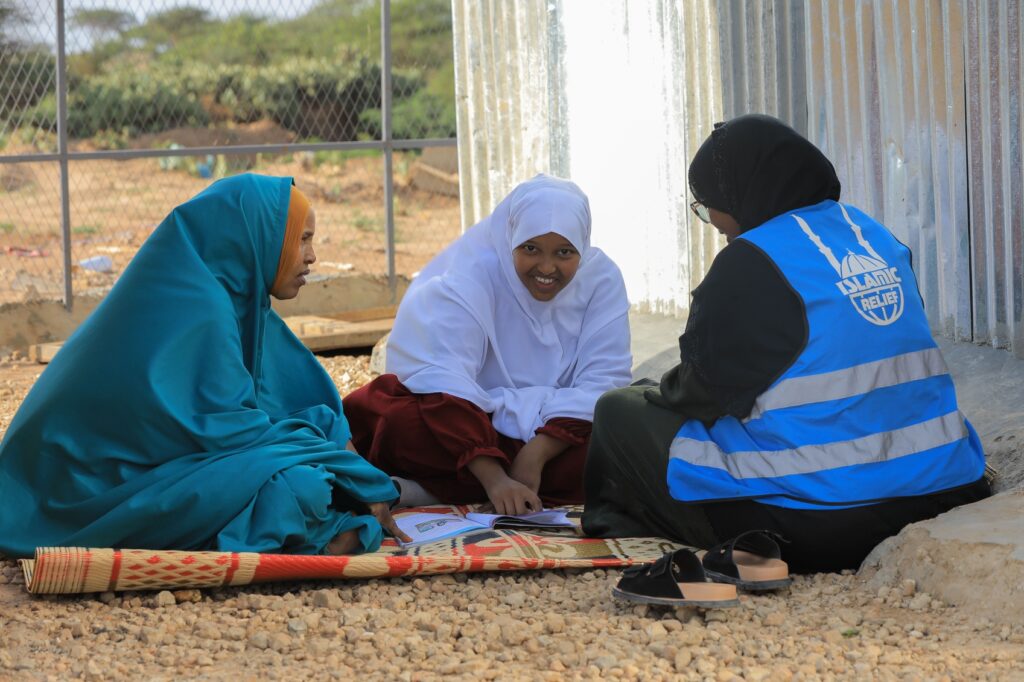 Ahlam and her mother Kos conversing with one of the Islamic Relief orphan staff