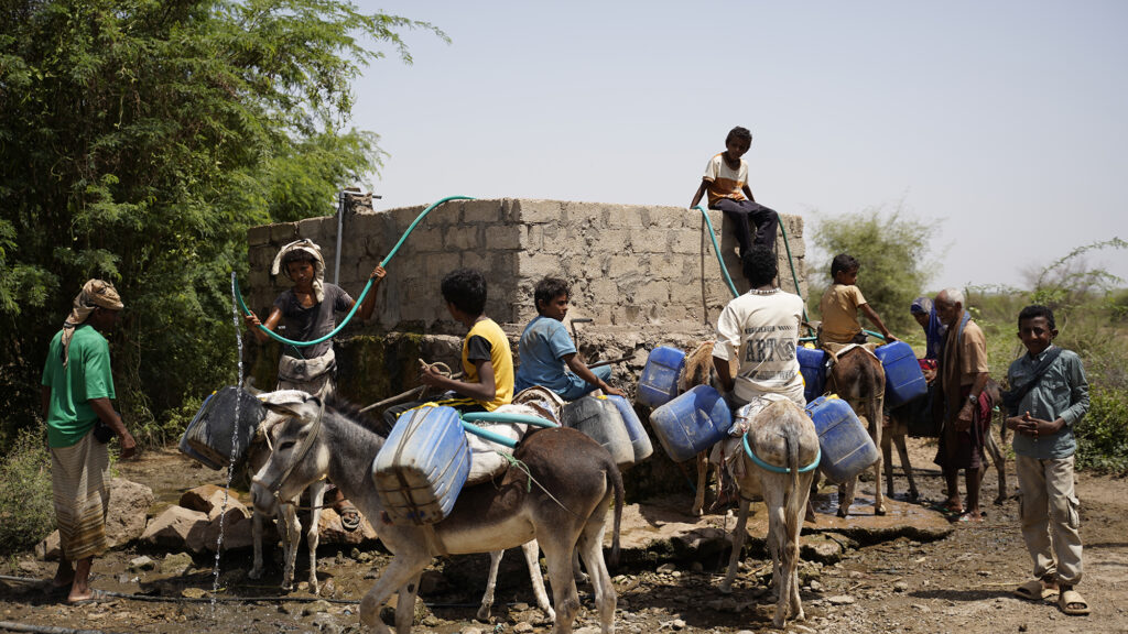 Children using the repaired water tank in their Yemen village