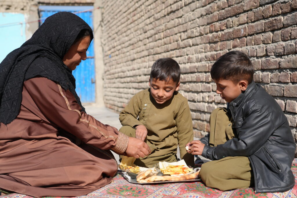 Hijran, his older brother and mother sharing a meal, made possible by Islamic Relief's Orphan Care program.