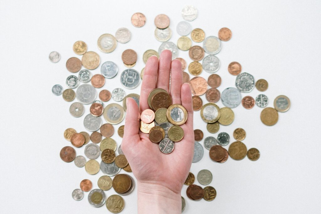 Hand holding coins, one of the zakat mistakes is to assume that any charity can count as such